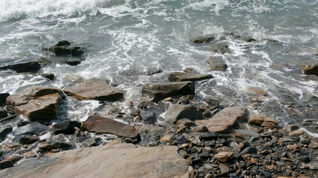 美丽的海浪在石滩上。视频素材