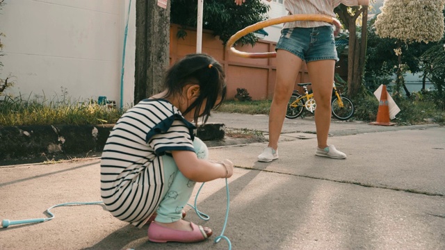 小女孩和她的妈妈跳绳和玩呼啦圈视频素材