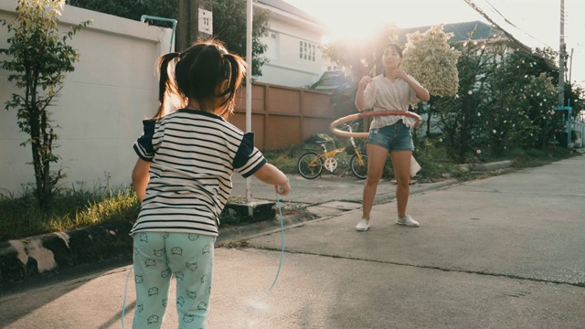 小女孩和她的妈妈跳绳和玩呼啦圈视频素材