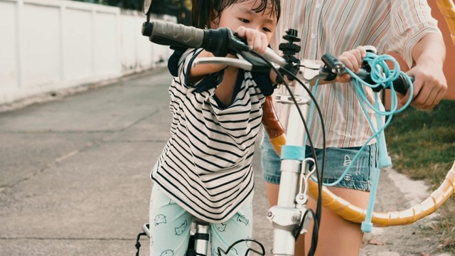 母亲和女儿在公路上骑车，一天在一个孩子的生活视频素材