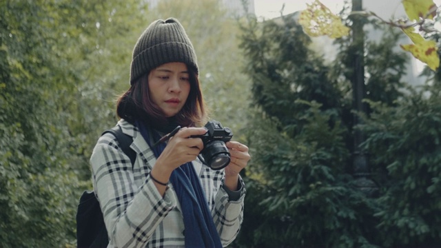 年轻的亚洲女子在中央公园用单反相机拍照。纽约视频素材