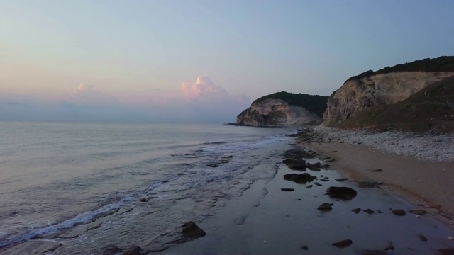 鸟瞰日出在沙石海滩-一个人走在海滩上视频素材