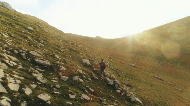 在日落时分，一名年轻人在意大利阿布鲁佐山的山脊边缘徒步旅行视频素材