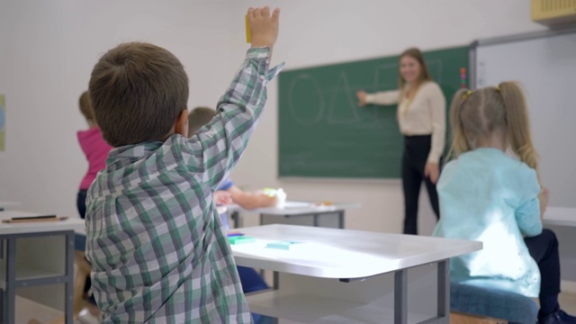 幼儿教学，学童在课堂上专心听讲教师在黑板上讲课视频素材