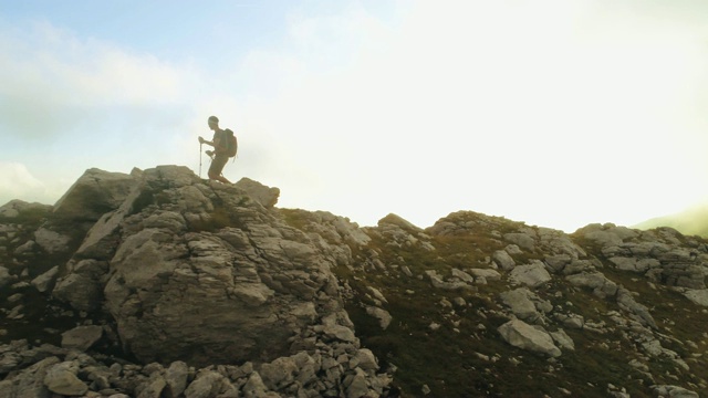 在日落时分，一名年轻人在意大利阿布鲁佐山的山脊边缘徒步旅行视频素材