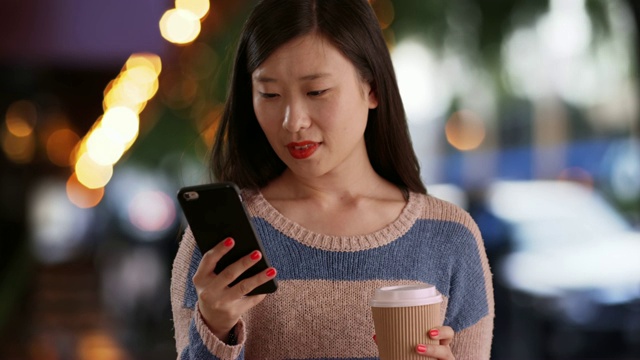 快乐的女人在城市咖啡馆前看智能手机短信的特写视频素材