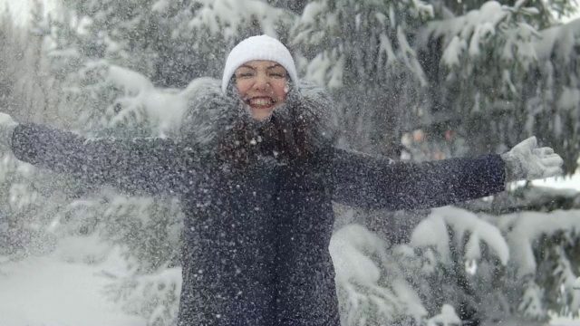 快乐的女人在冬天的森林里享受降雪。在新鲜空气中散步视频素材