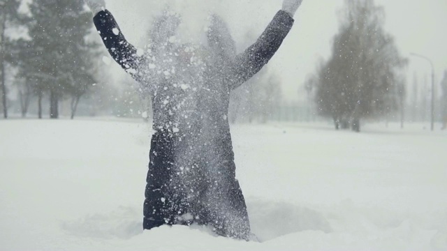 在冬季公园里愉快地散步。雪堆里的年轻女子视频素材