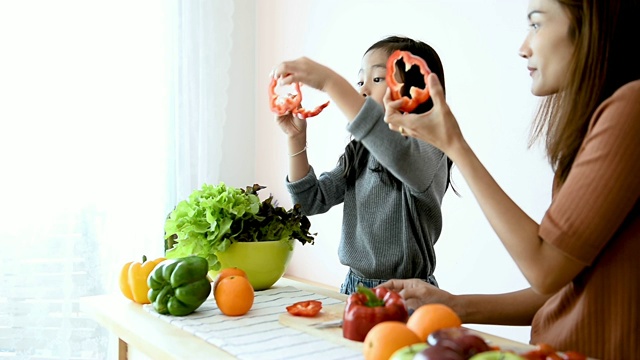 妈妈在教女儿如何切菜和做饭视频下载