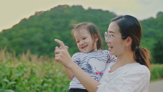 母亲和女儿在日落的大自然中散步视频素材