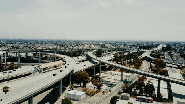 无人机正飞行在高速公路交叉路口，交通在多个道路水平和立交桥之上。视频素材