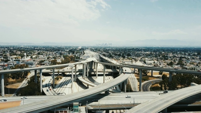 无人机在洛杉矶高速公路十字路口向前飞行，交通四通六达。视频素材