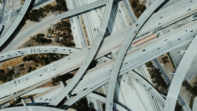 俯视图无人机在高速公路立交桥上快速旋转，汽车在多个立交桥、道路和桥梁上移动。视频素材