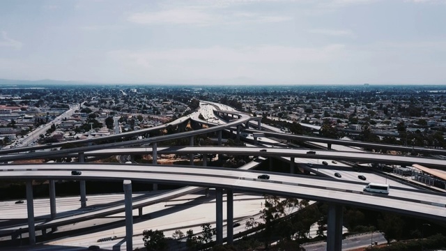 无人机在复杂的高速公路十字路口上空降落，交通通过多个立交桥和桥梁。视频素材