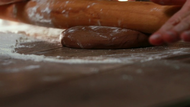 女性的手在木桌上滚动生姜面团。传统的圣诞烘烤。视频素材