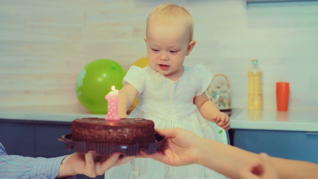 婴儿正试图吹灭生日蛋糕上的蜡烛视频素材