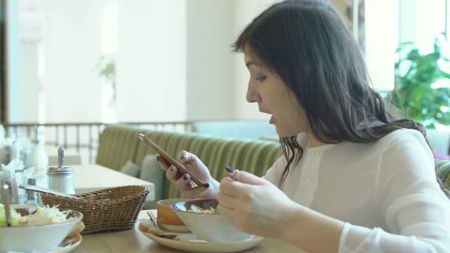 年轻女子在咖啡馆与电话。午休时间视频素材