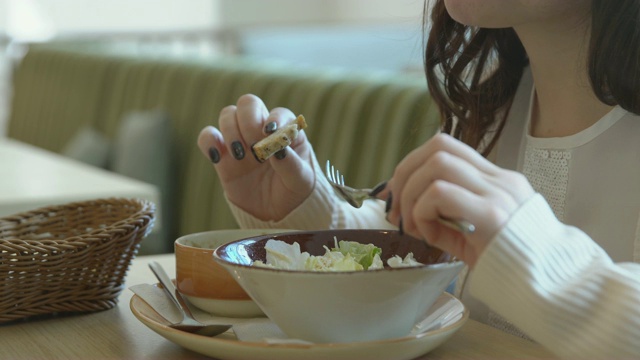 午休时间。一位年轻女子在咖啡馆用餐视频素材