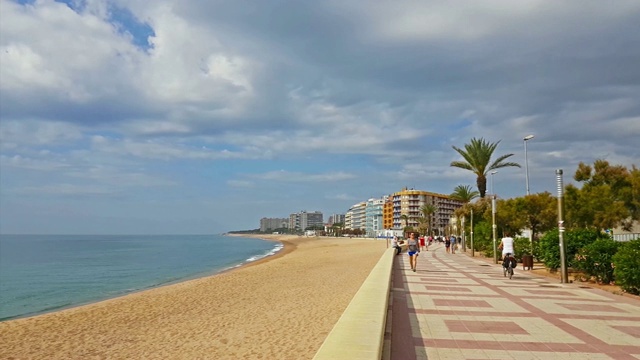 布雷恩市的沙滩海岸。地中海的海浪冲刷着多云的海滩，游客们在那里晒太阳和游泳。科斯塔布拉瓦，加泰罗尼亚，西班牙视频下载