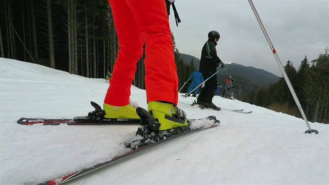 滑雪者将滑雪靴固定在滑雪板上，然后下山。视频素材