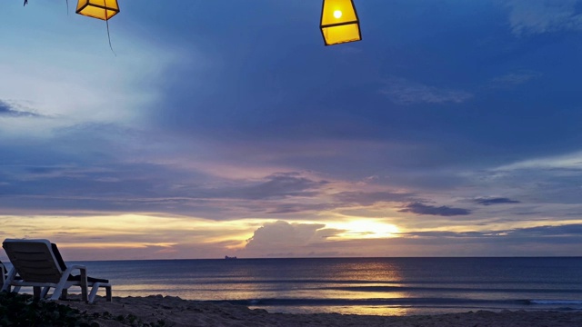 太阳躺椅上的热带海滩日落与黄色灯笼上面视频素材