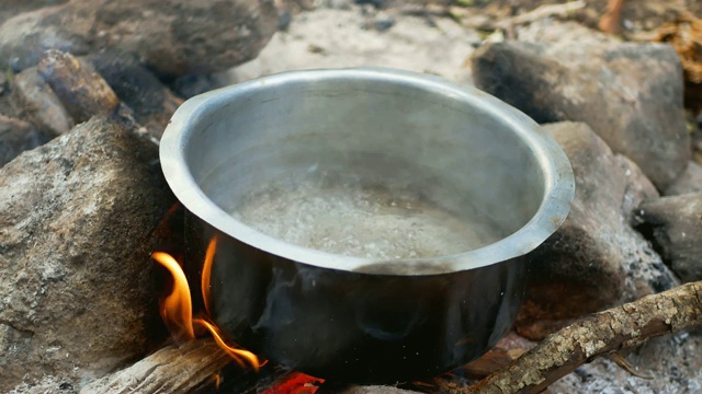 在篝火上的锅里烧开水视频素材