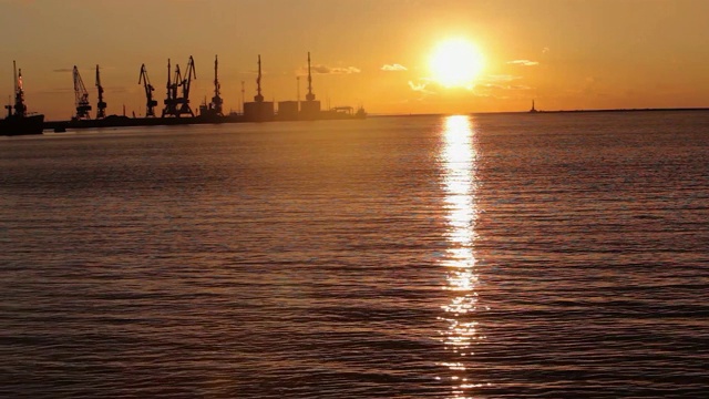 起重机在海港日落，海港附近的海港，美丽的海景，大海港日落视频素材