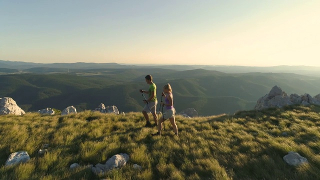 空中摄影:在阳光明媚的群山中徒步旅行的活跃的男男女女。视频素材