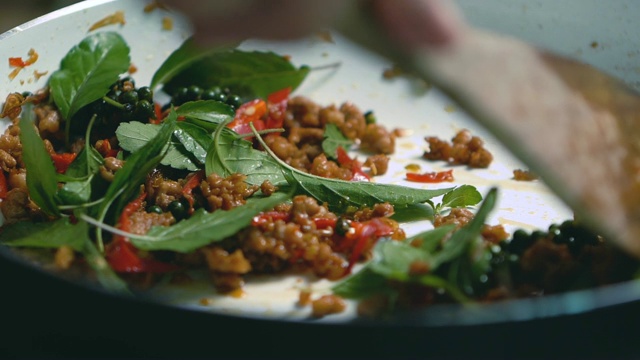 慢动作的近近炒碎猪肉与热罗勒，亚洲泰国菜辛辣的食物概念。视频素材