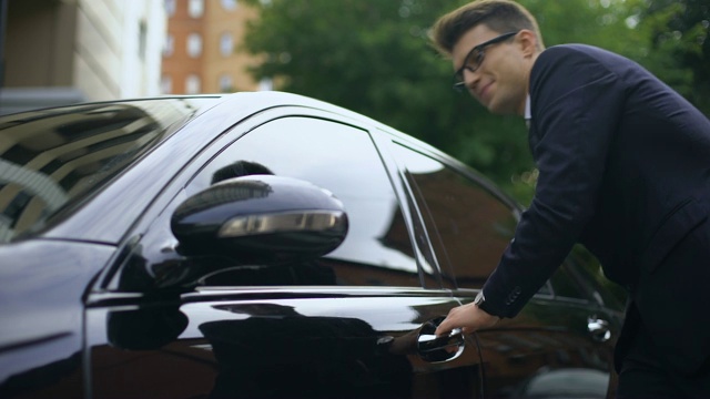 穿着西装的高兴的男人摸着车，上车，赚钱买东西视频素材