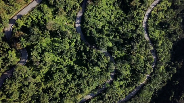 鸟瞰图蜿蜒的道路在森林和汽车驾驶，安全驾驶的概念视频素材