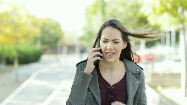 一个愤怒的女人在公园里打电话争吵视频素材