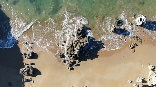 航拍岩石海滩溅起水花的画面视频素材