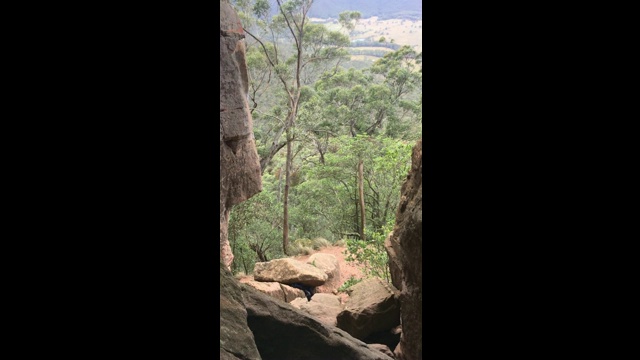 喜欢冒险的徒步旅行者穿过可以看到山谷景色的洞穴视频下载