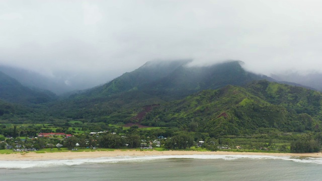 夏威夷考艾岛的哈纳莱伊湾在海滩山附近飞行视频素材