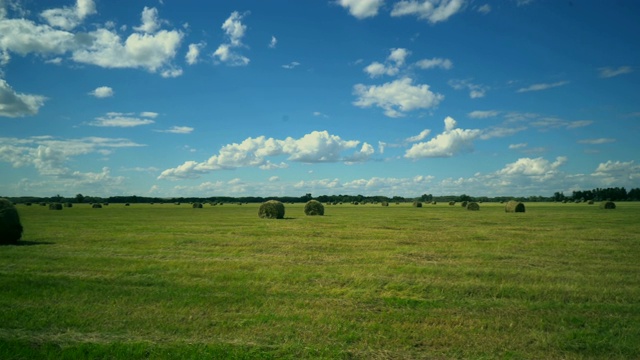 一捆捆干草在田野上与美丽的云天空视频素材