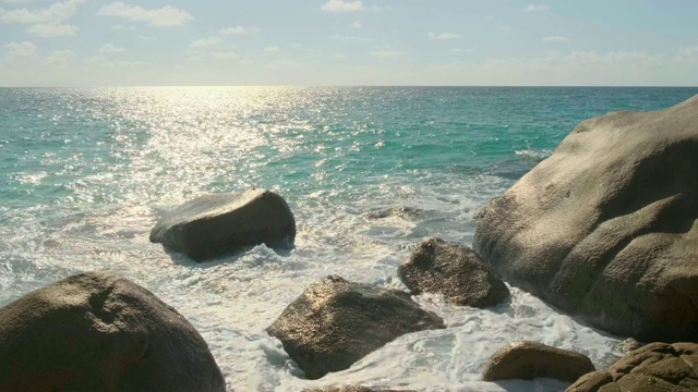 观看日落时海岛海滩上的浪花。安塞拉齐奥海滩，普拉林岛，塞舌尔美丽的岛屿上的海浪4k 59,94 fps视频素材