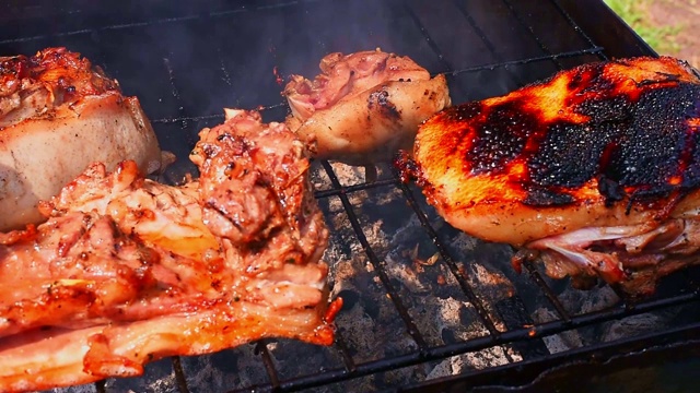 烹饪烟熏美味多汁的肉排在慢动作烤架上的火和烧烤烟熏在聚会，郊游视频素材