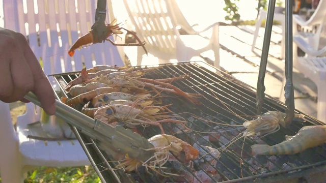 一群朋友在海滩上烧烤猪肉、虾和海鲜聚会活动视频素材