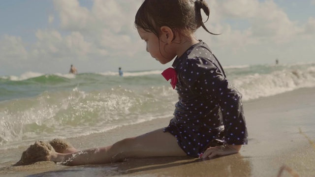 小女孩在海滩上玩海浪视频素材