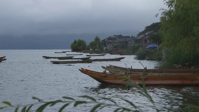 暮色苍茫下，泸沽湖沿岸的船只和房屋视频素材