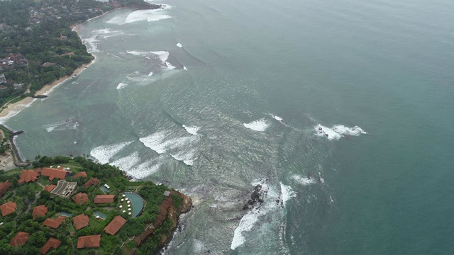 鸟瞰图。无人机从空中拍摄海浪和渔村景观视频素材