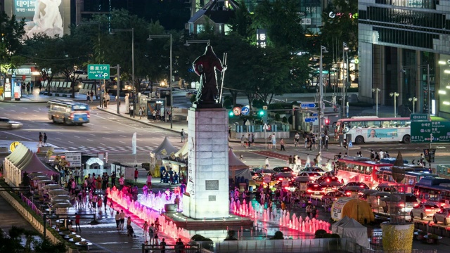 夜景:游客经过光华门广场的李舜臣(朝鲜王朝历史上的海军司令)铜像和喷泉视频素材