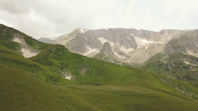 无人机鸟瞰雪山山峰和绿色草地景观视频素材