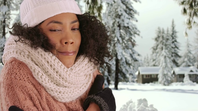 近距离观察可爱的黑色女性在舒适的帽子和毛衣颤抖在白雪覆盖的森林视频素材