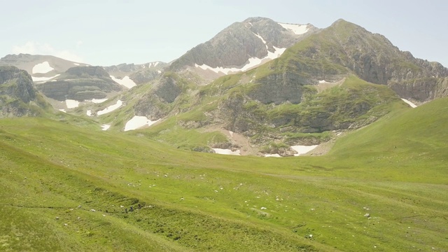 夏季景观徒步行走在绿色草地上山谷无人机的观点视频素材