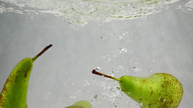 梨子在慢镜头中溅起水花，冒出泡泡。视频素材