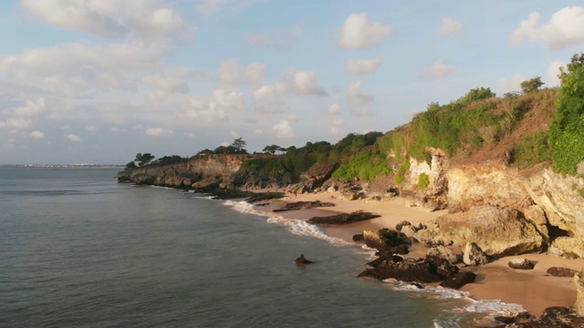 鸟瞰图悬崖，海滩和海洋在热带岛屿在温暖的日落视频素材