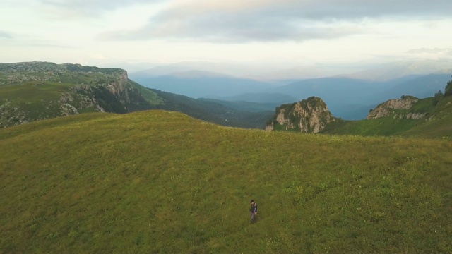 空中景观无人机在山上的绿色草地上飞行视频素材