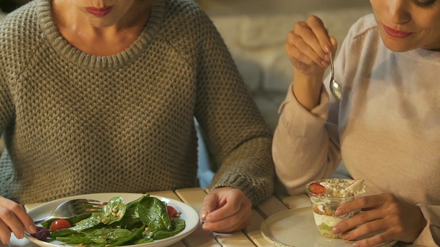 女人喜欢吃甜点，嘲笑朋友吃沙拉，垃圾食品vs健康视频素材